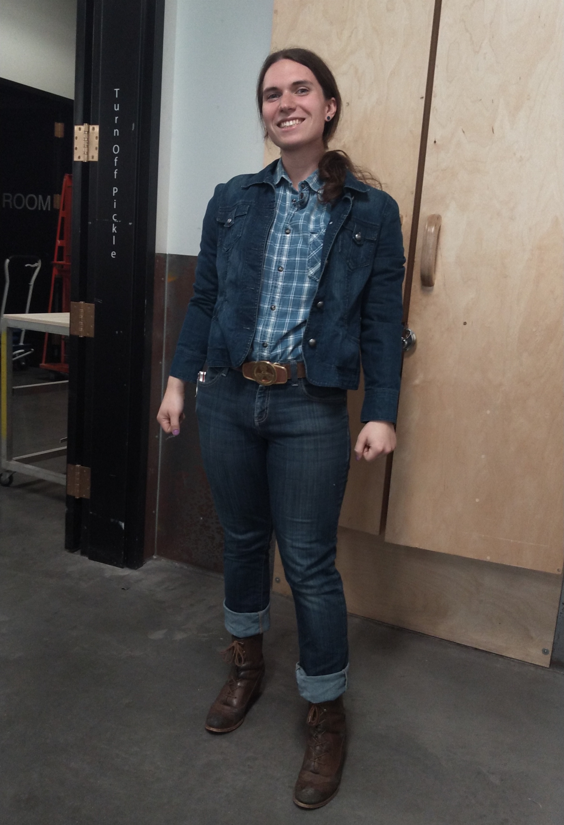 A picture of me crouching behind a painted wooden chest