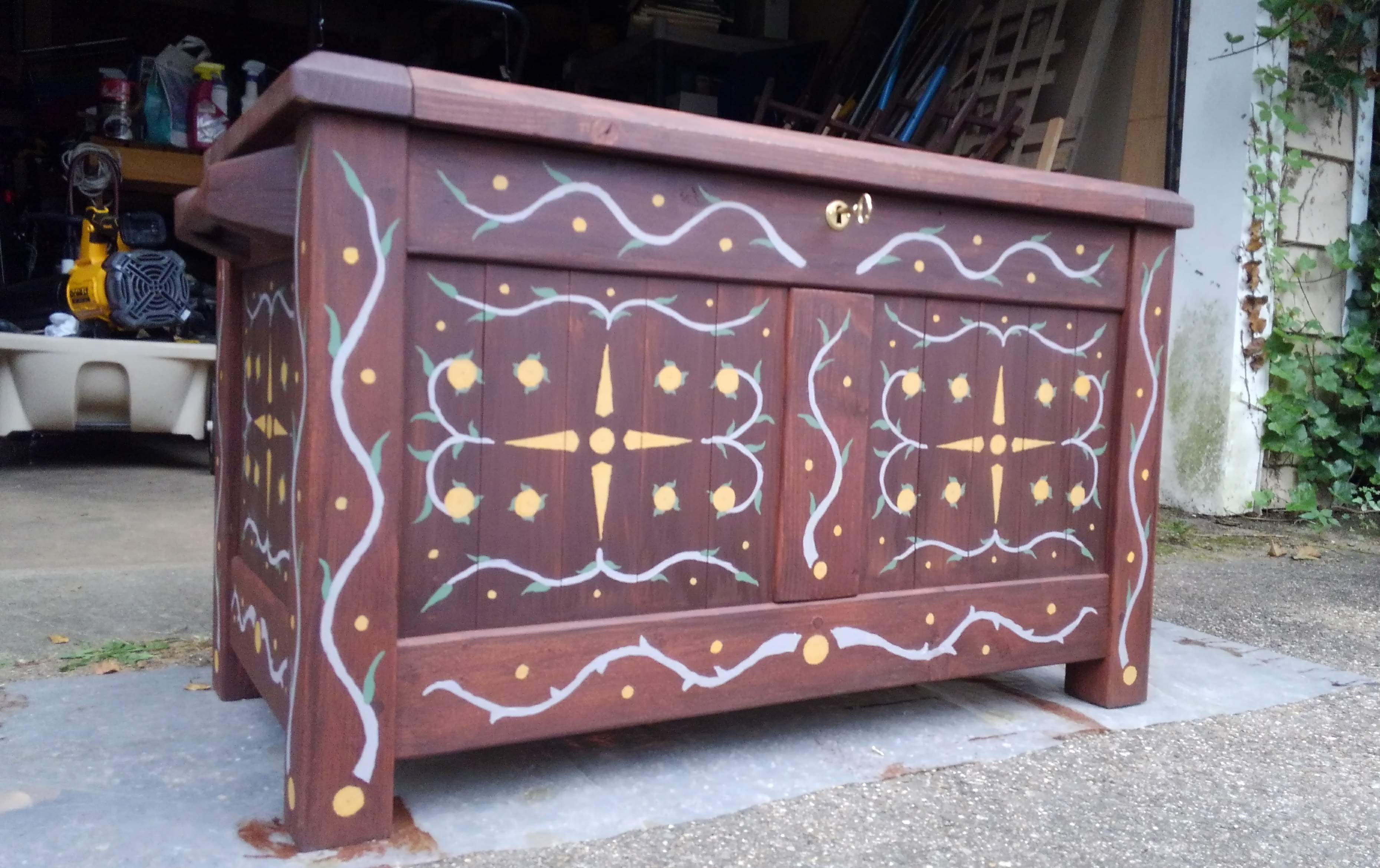 a brown wooden chest covered in branch-like designs