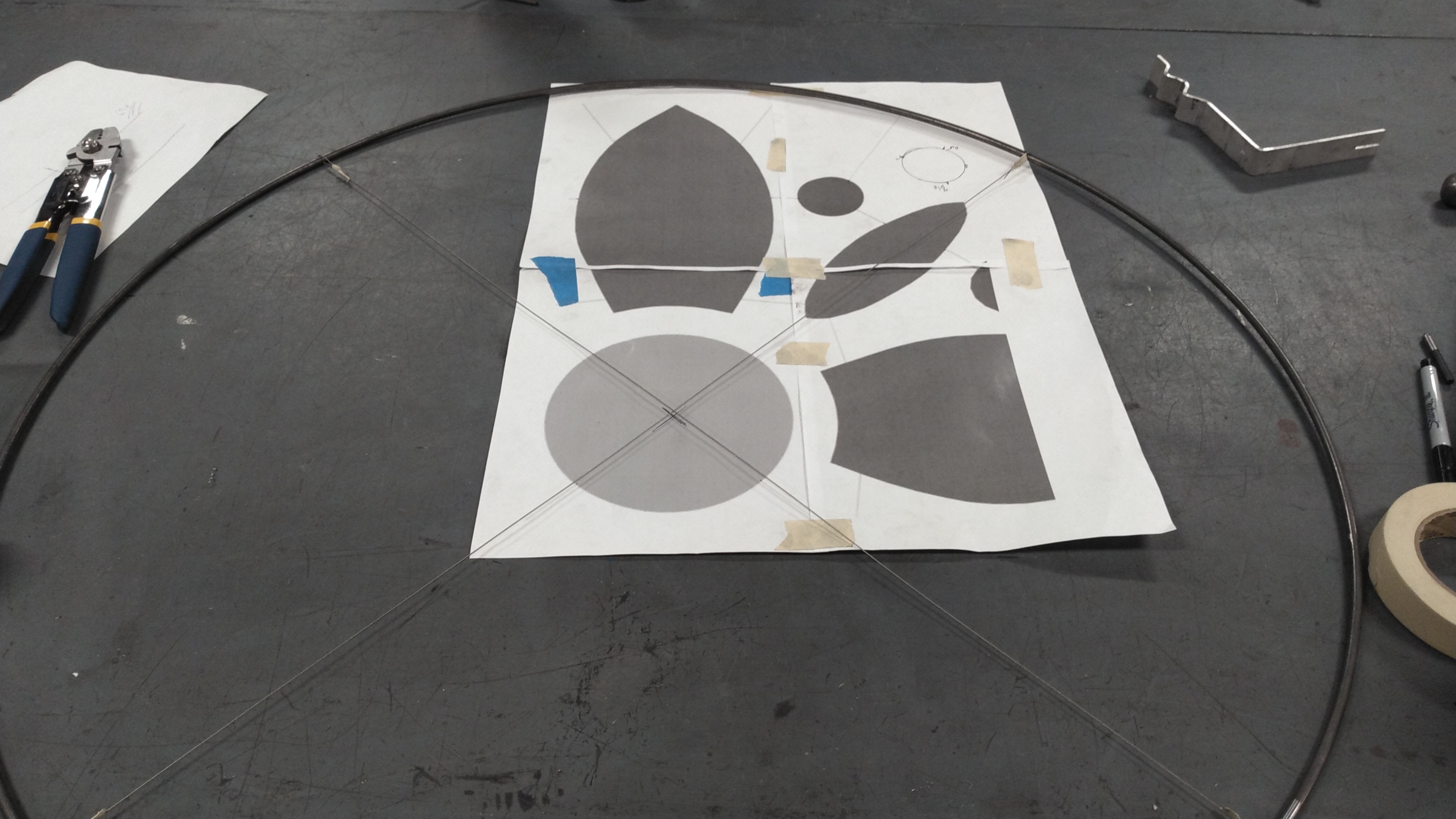 A metal sculpture being laid out overtop a printed design