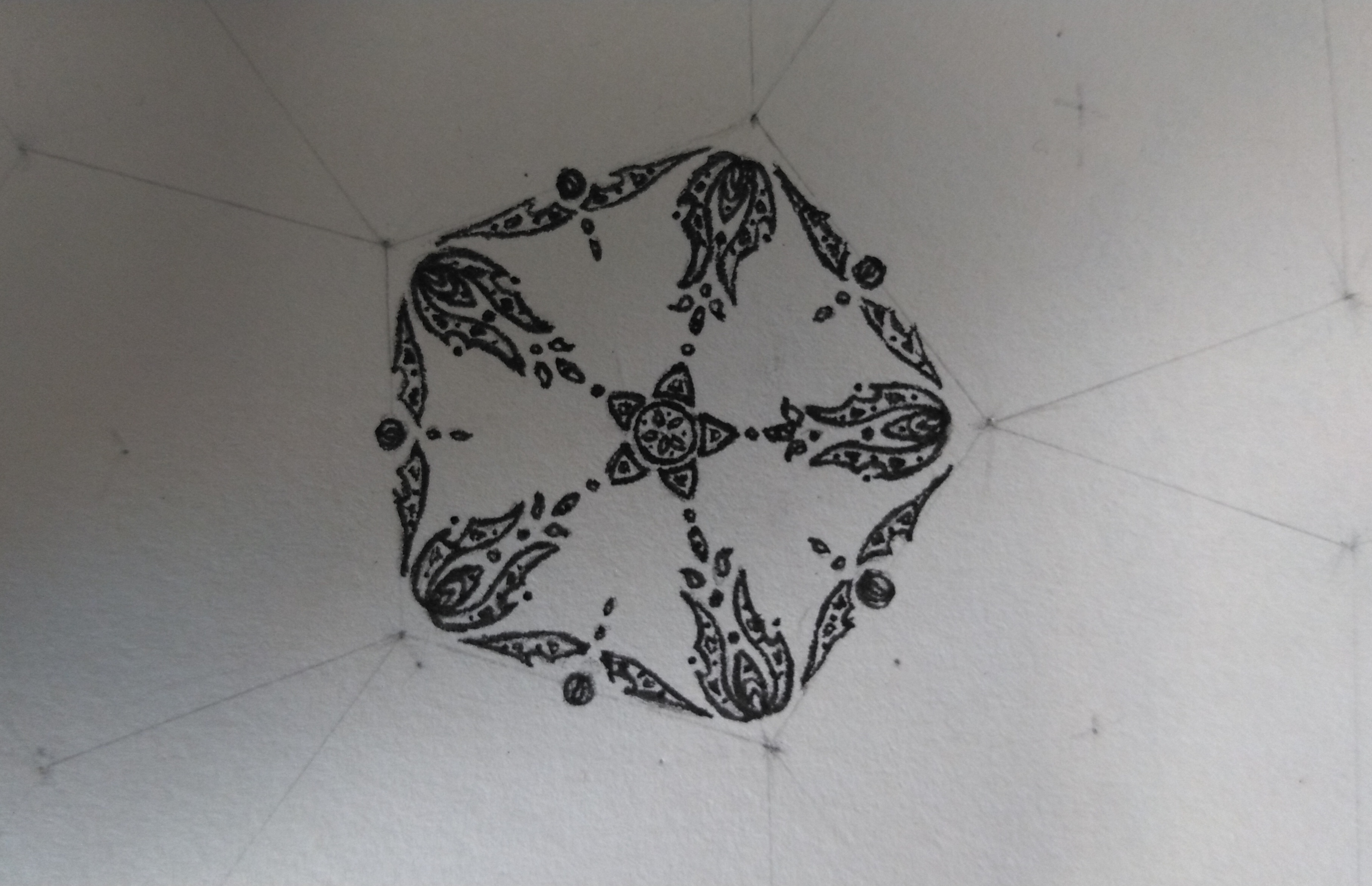 An ornamented pattern in progress. It is drawn over a grid of pentagons and diamonds.