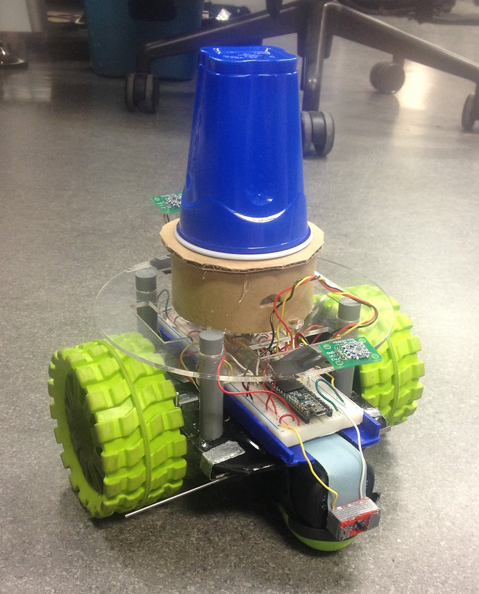 a two-wheeled robot with a blue cup sitting on top of it