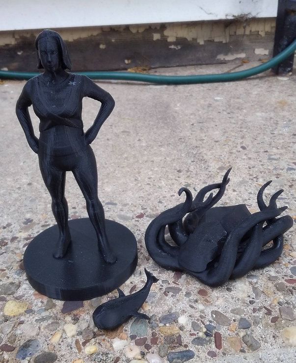 a 3D printed superhero figure, whale, and octopus
