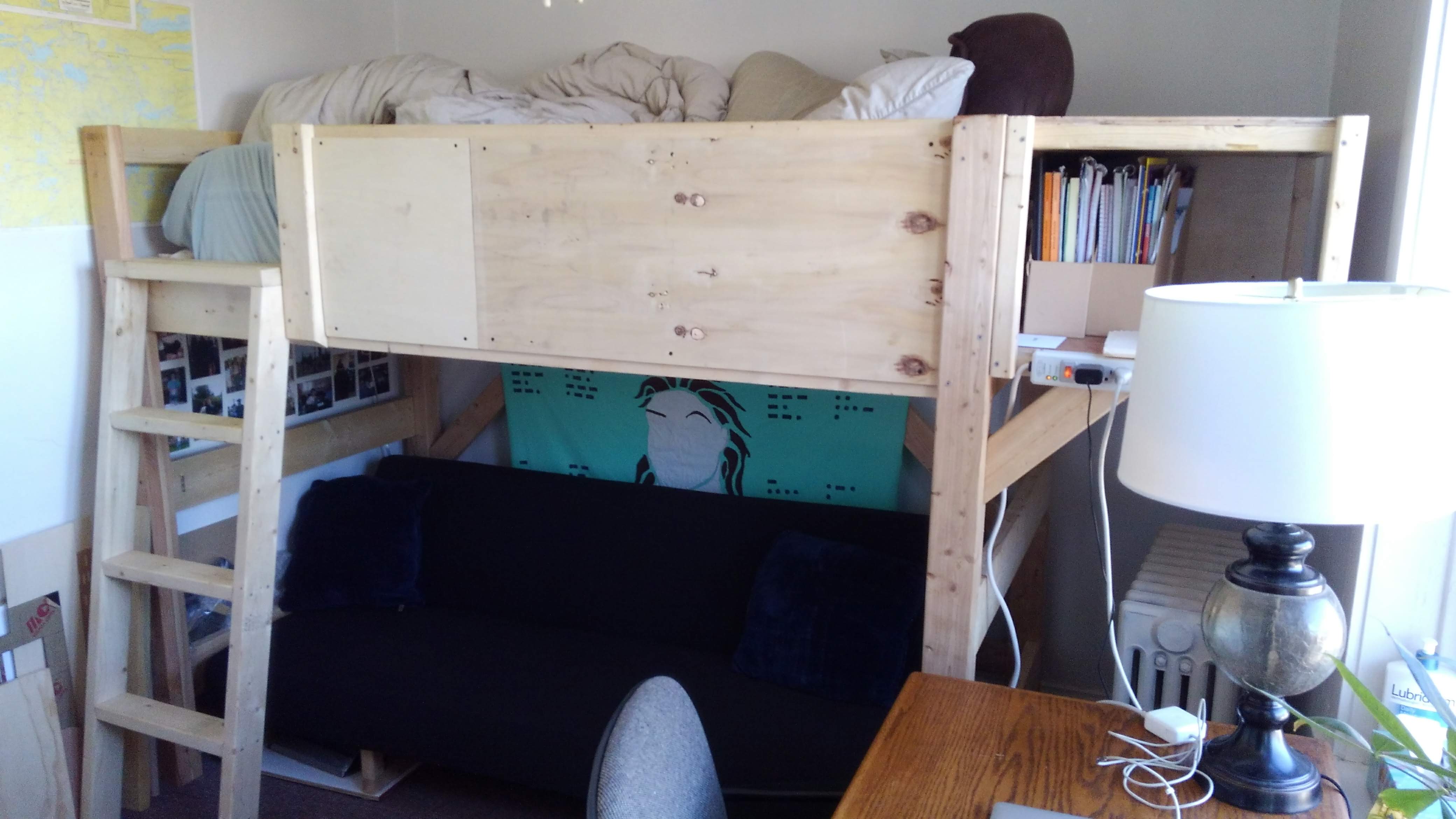 a lofted bed with a ladder over a futon