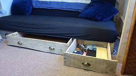 three drawers sliding out from the bottom of a futon