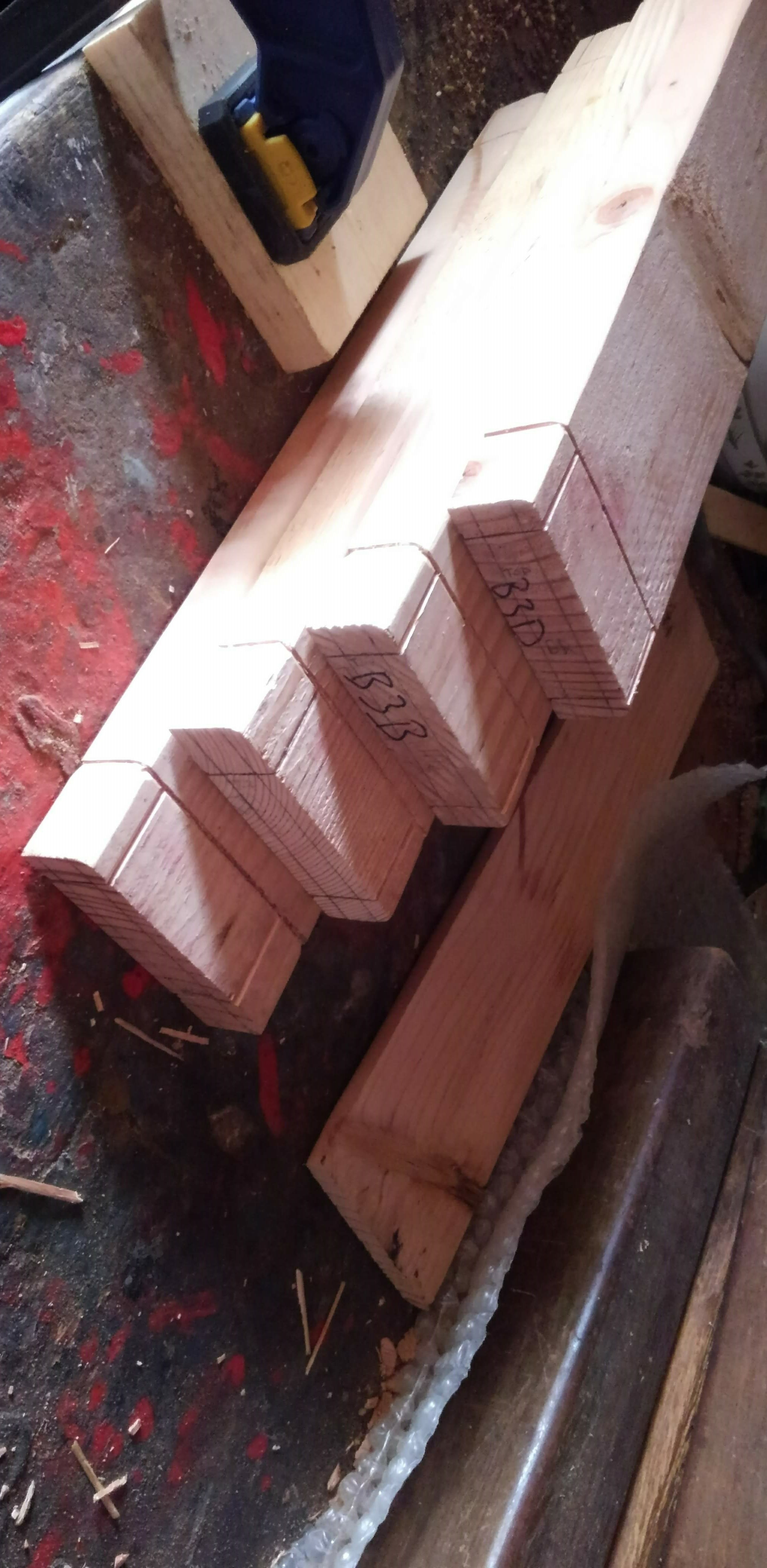 a stack of wood scribed with layout lines for tenons