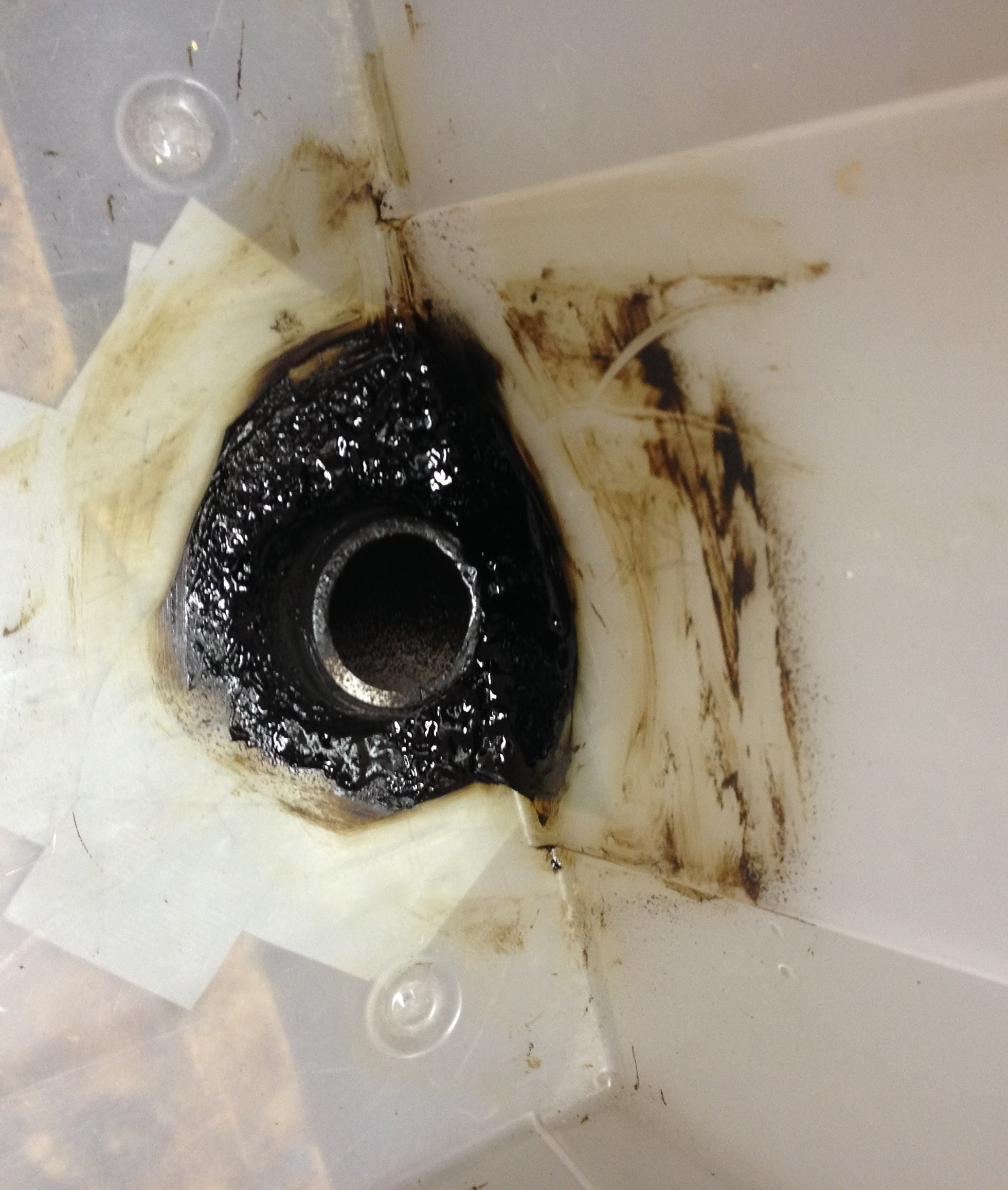 a pipe fit into the bottom of a storage bin, sealed with spray sealant