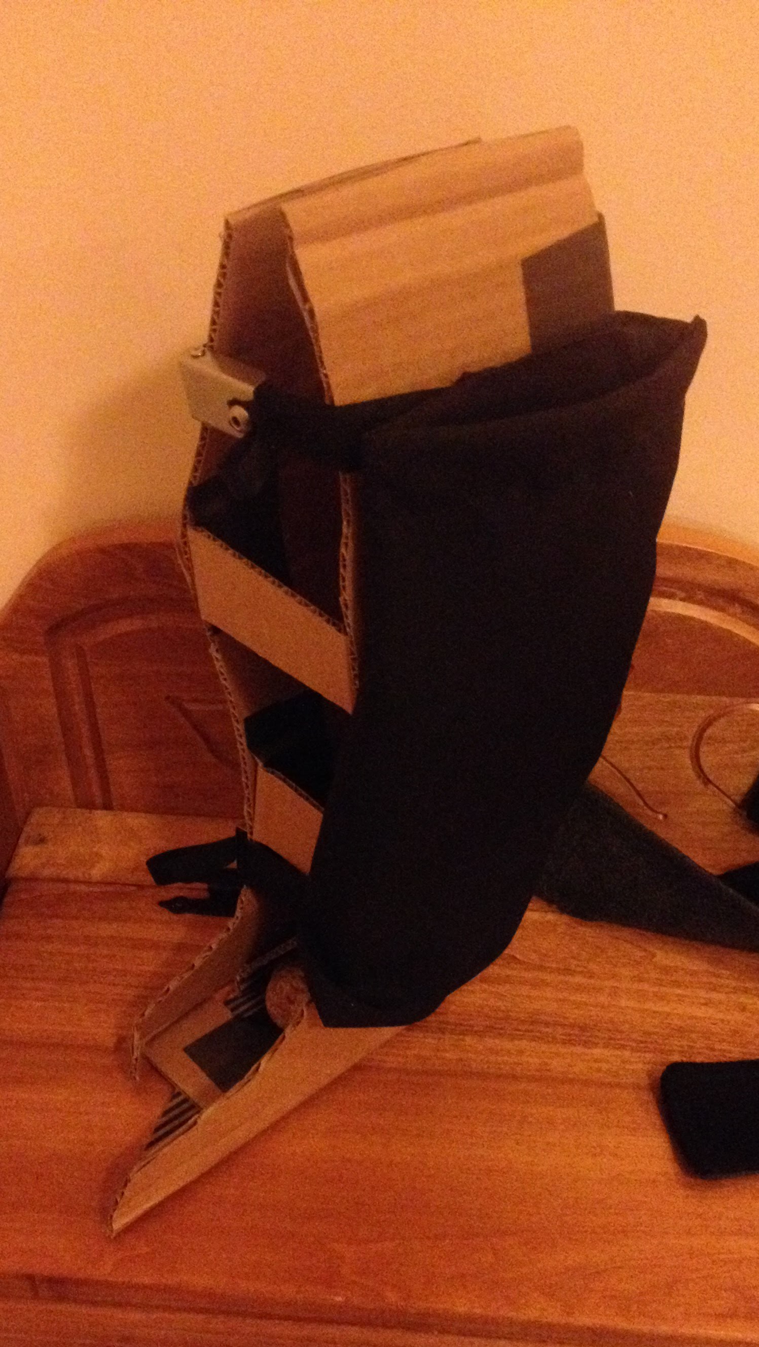a cardboard leg form modeling a black pouch